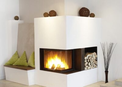 Moderner Eck-Kamin mit Sitzgelegenheit und Holzlager