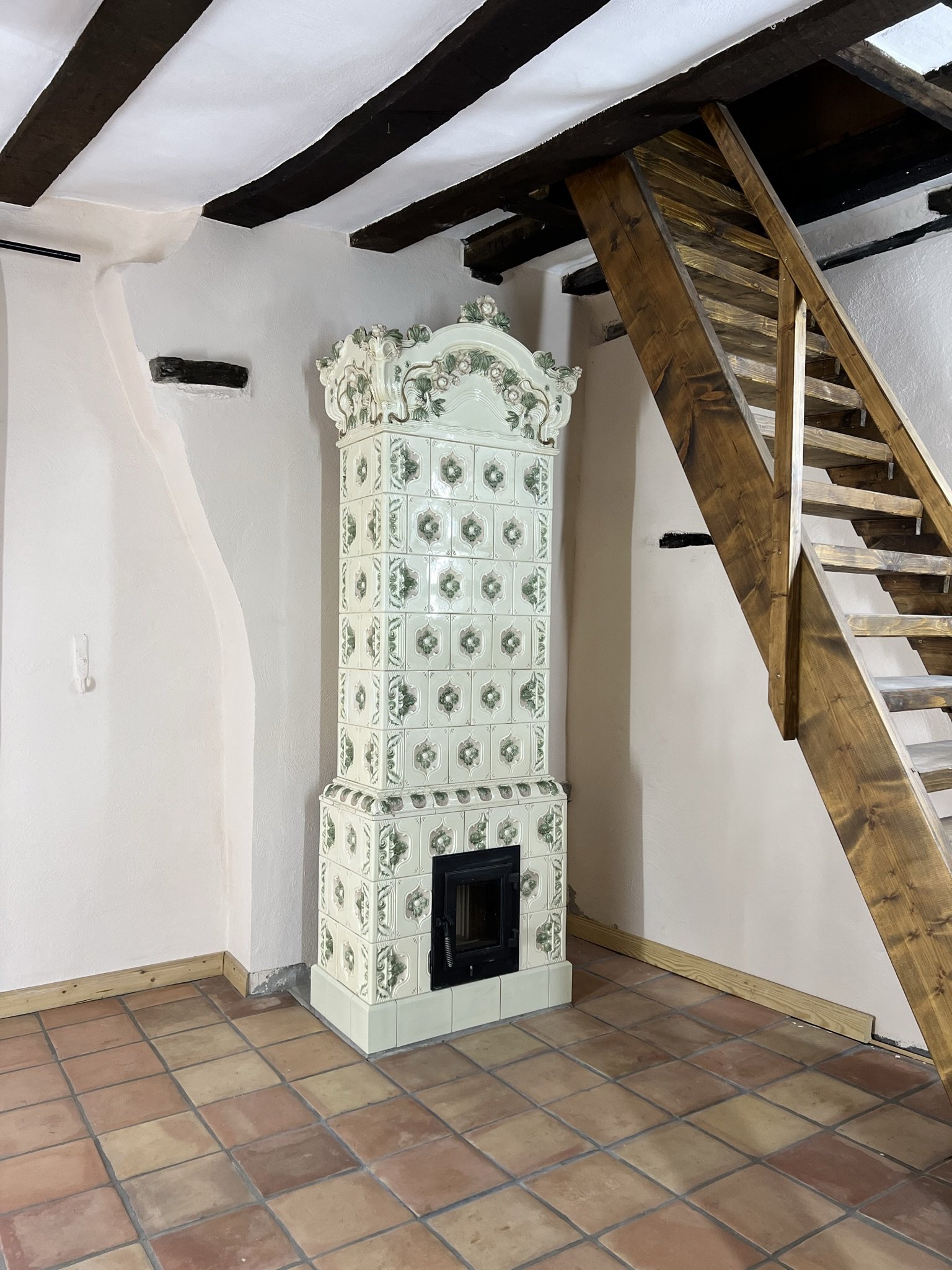 Historischer Kachelofen mit Ornamentik in einem restaurierten Fachwerkhaus